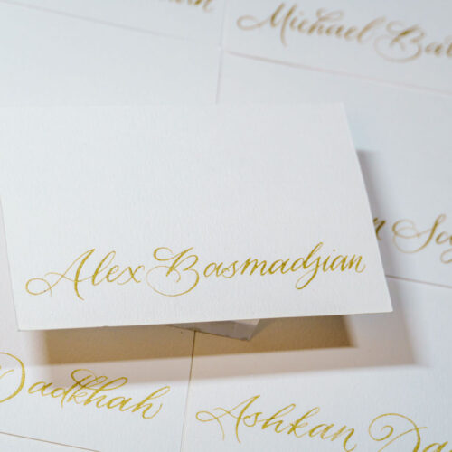 Hand-written gold calligraphy on name cards by KeeKee Creates for weddings.